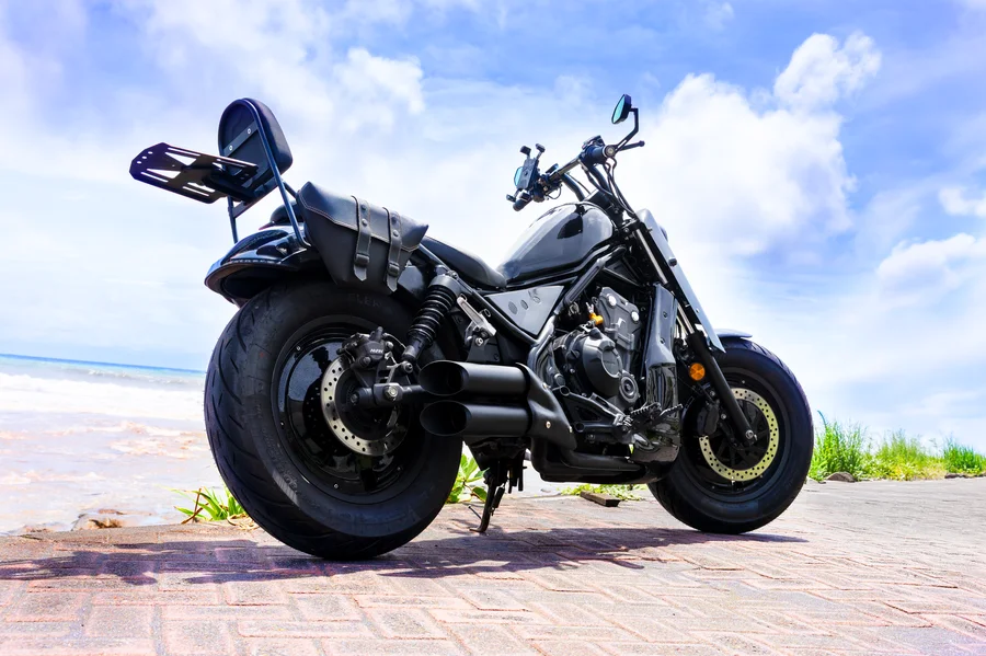 Black Honda Rebel 500 custom chopper with comfortable rider seat, rear passenger seat and backrest, twin saddlebags and luggage rack