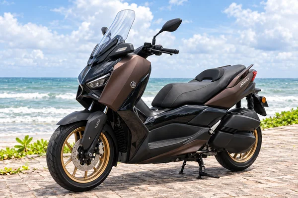 Bronze Yamaha XMAX 250 TECH MAX with gold wheels, front three-quarter view