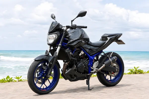 Black and blue Yamaha MT-25 V1 upright 250cc naked motorcycle with exposed parallel-twin engine