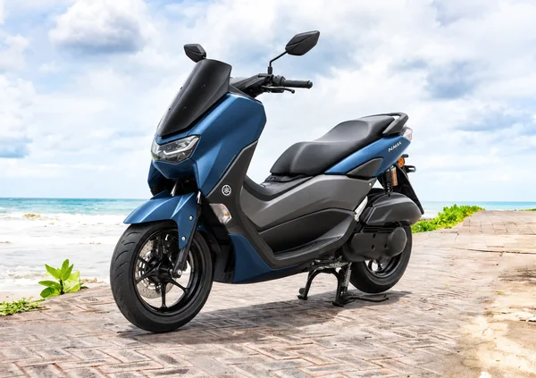 Blue second-generation Yamaha NMAX155, front-left view, beside the ocean