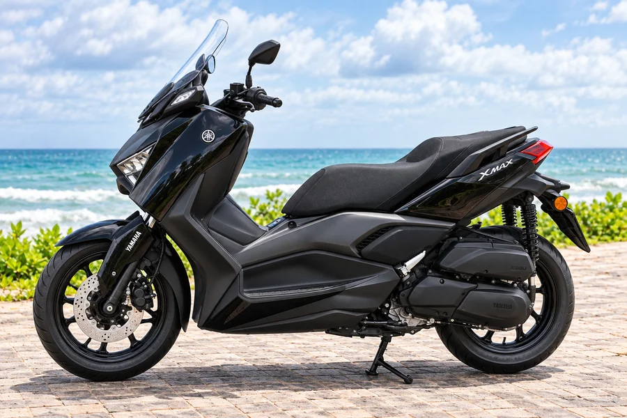 Black Yamaha XMAX 250 Connected, front-left view, beside the ocean