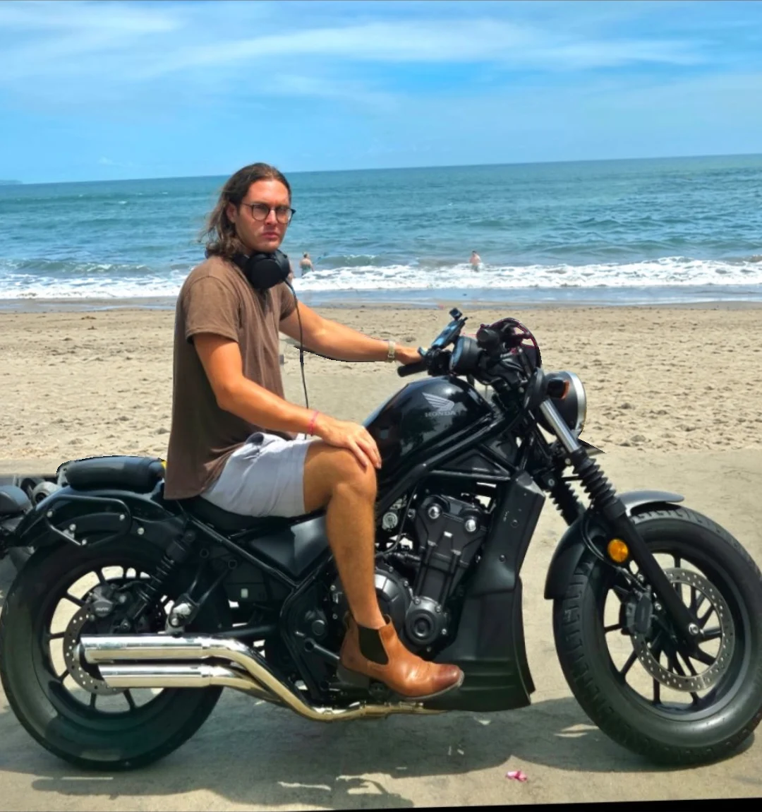 Kaleb on a black motorcycle by the sea
